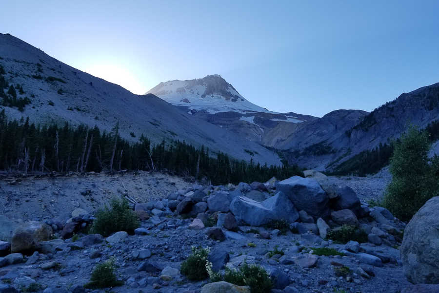 Mt. Hood at sunset. The mountain is at the top with fallen rocks laying around the bottom 