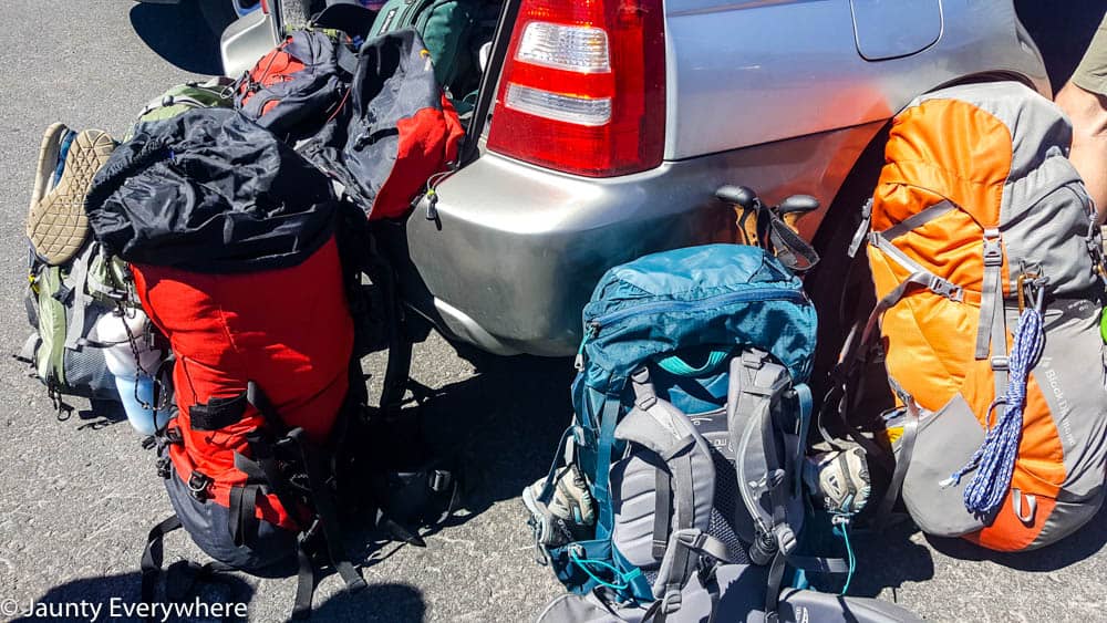 Backpacks leaned against the back of a car.