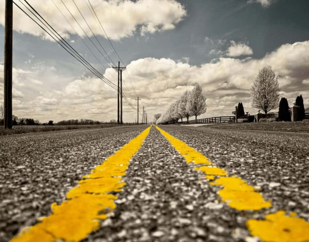 Yellow road marks fading into the distance of a road
