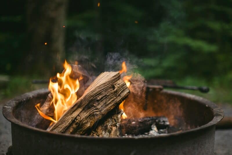 a fire of logs in a campground firepit