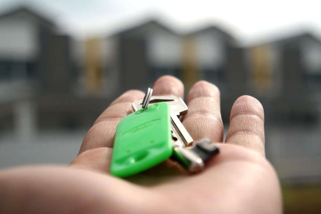 handing over a set of green keys when leaving the house