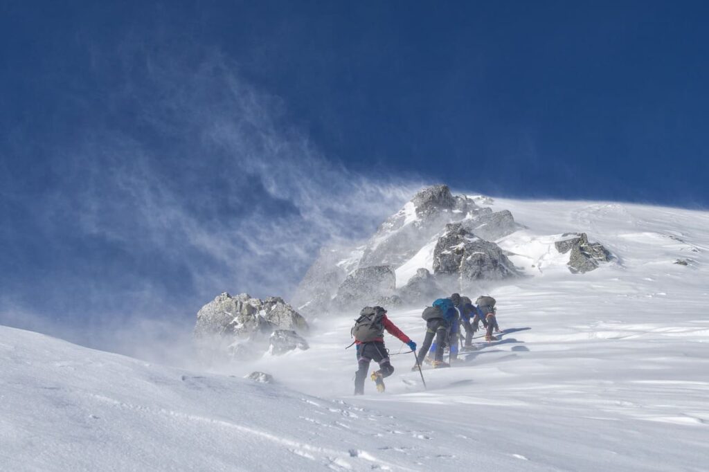 group of mountain climbers in swirling snow