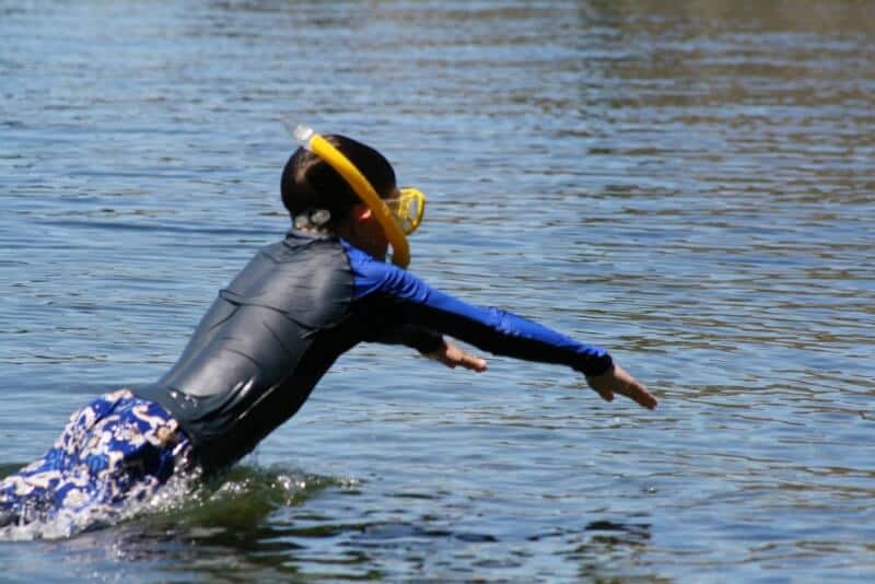 boy diving into the water with a mask and snorkel