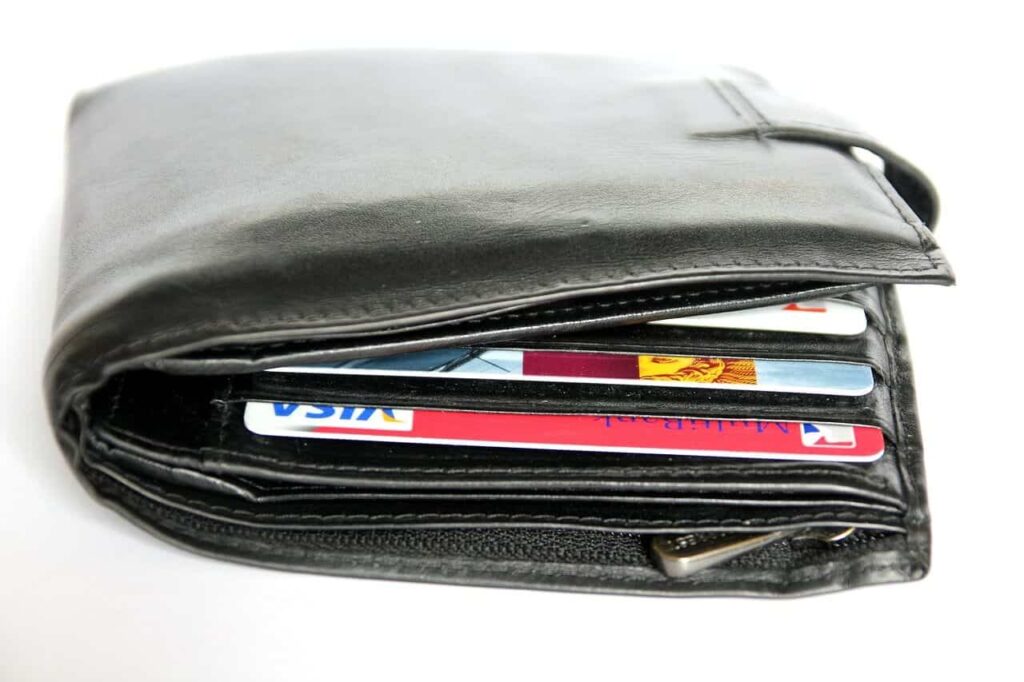 black leather wallet stuffed with cards