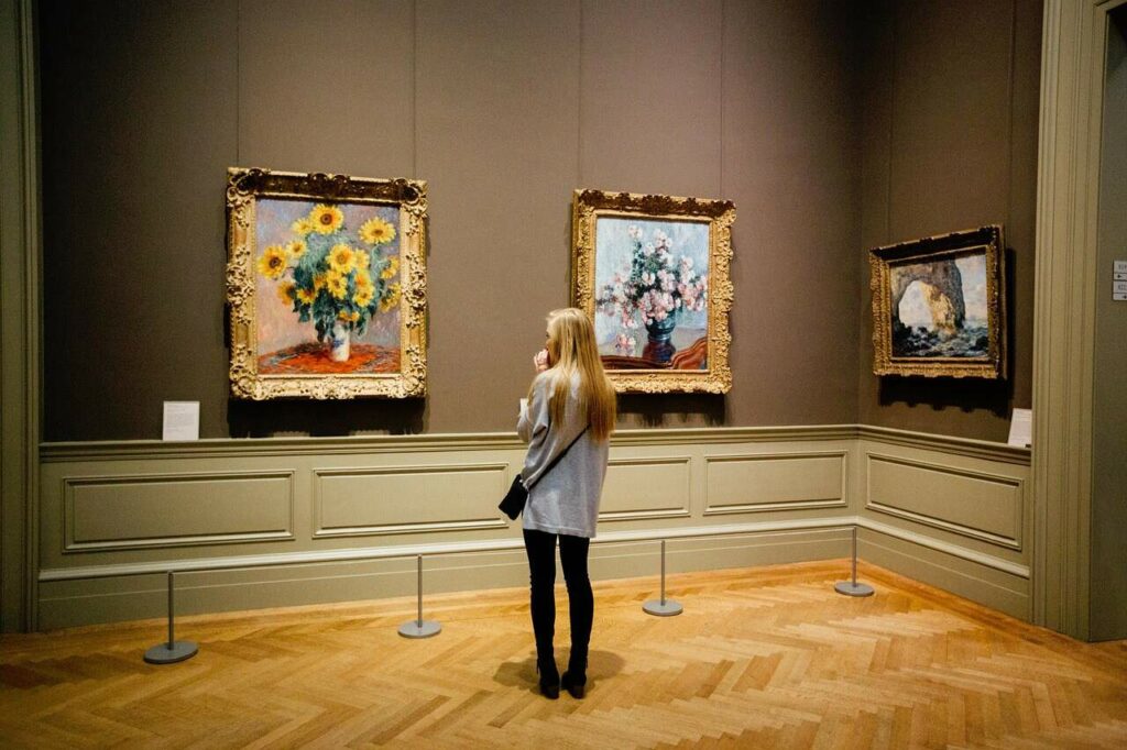 woman gazing at impressionist art in an art museum 
