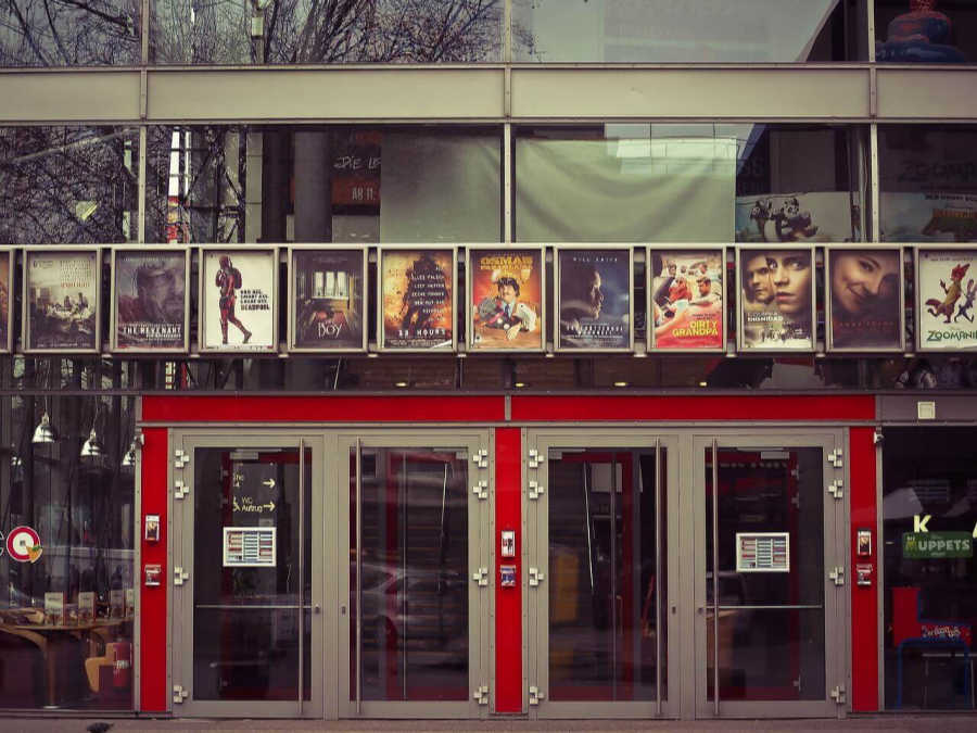 the front of a cinema, movie posters line the front window
