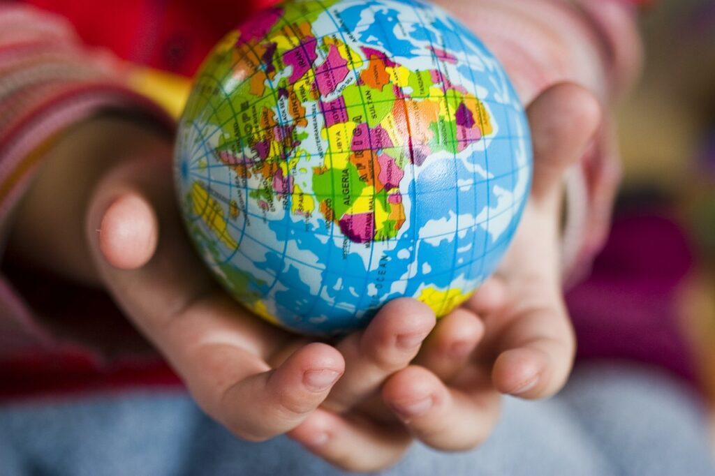 exploring cultures and countries: a child's hands holding a colorful globe