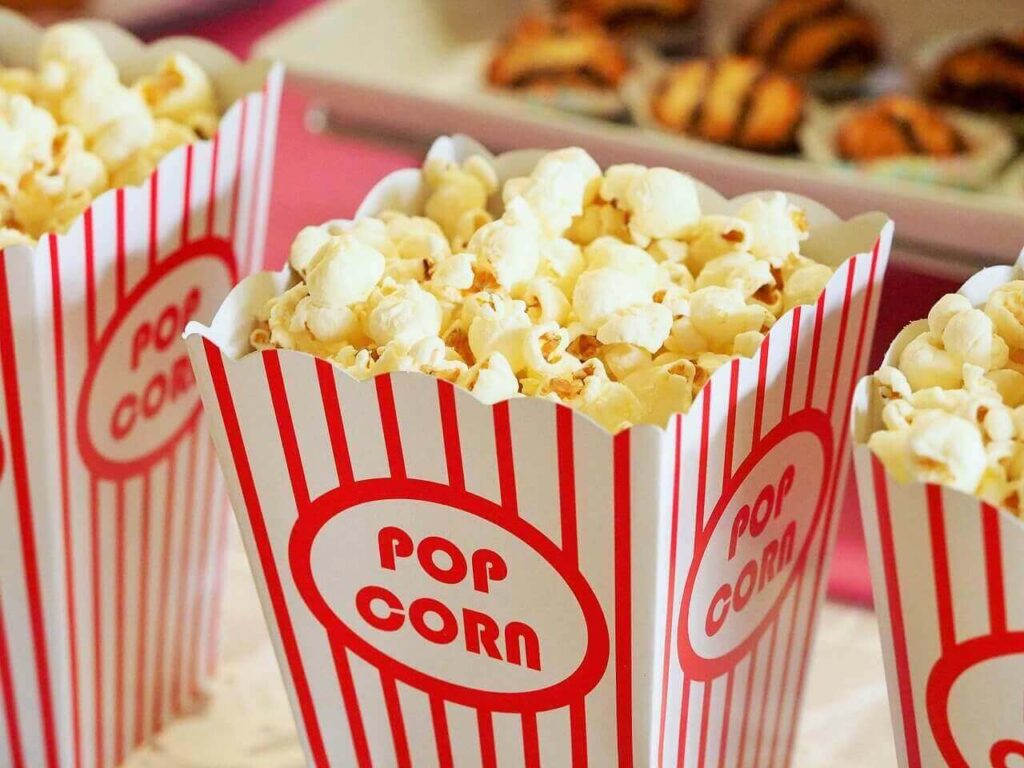 red and white movie popcorn containers filled with buttery popcorn