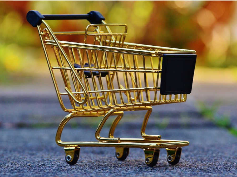 a miniature gold shopping cart on asphalt