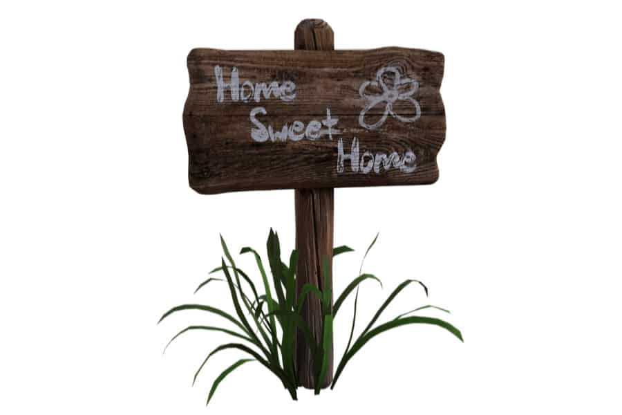 Wooden sign in the grass, it says home sweet home