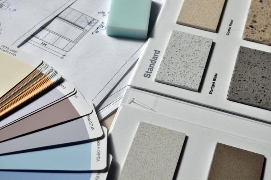 decorator samples spread out - paint swatches, blueprints, tile samples