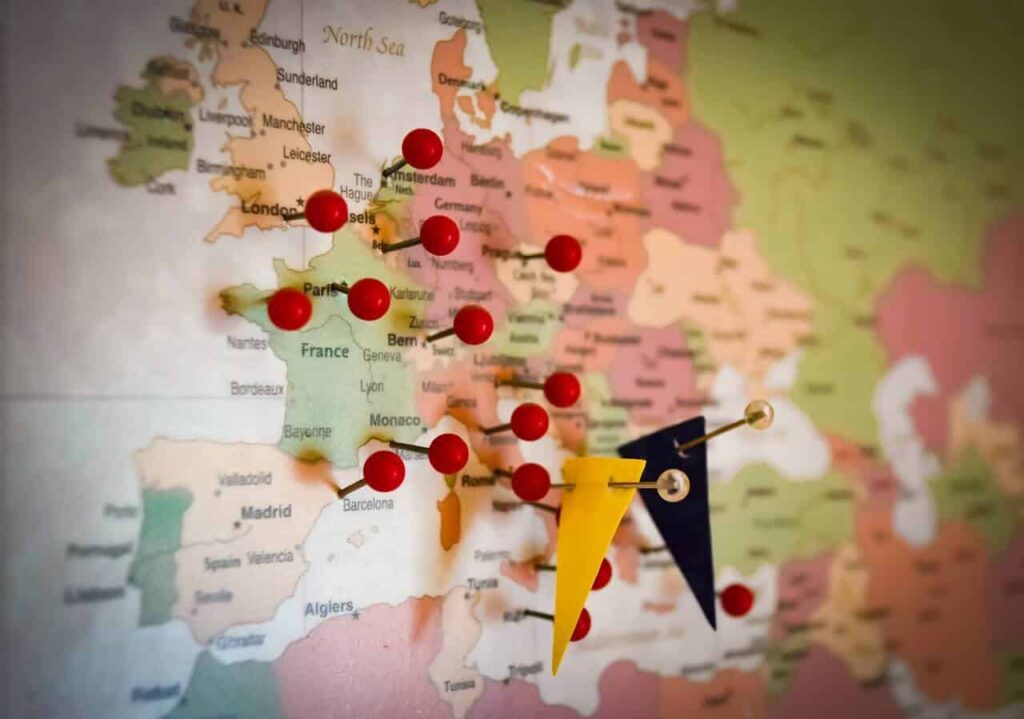 A map of the world with bright red stick pins marking the spot, Enneagram Type Three travelers checking things off the bucket list
