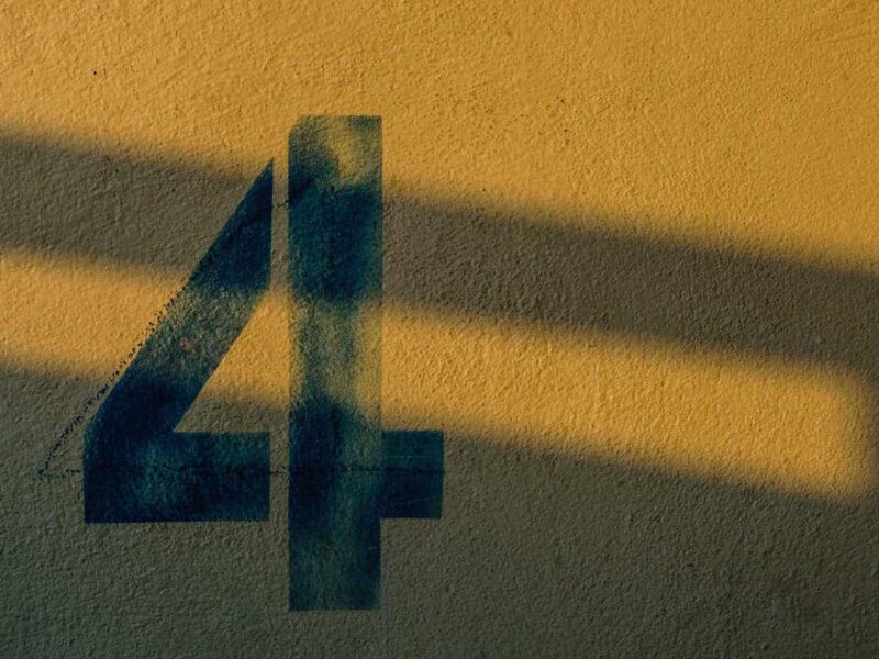 stenciled numeral four on a yellow background, in shadow