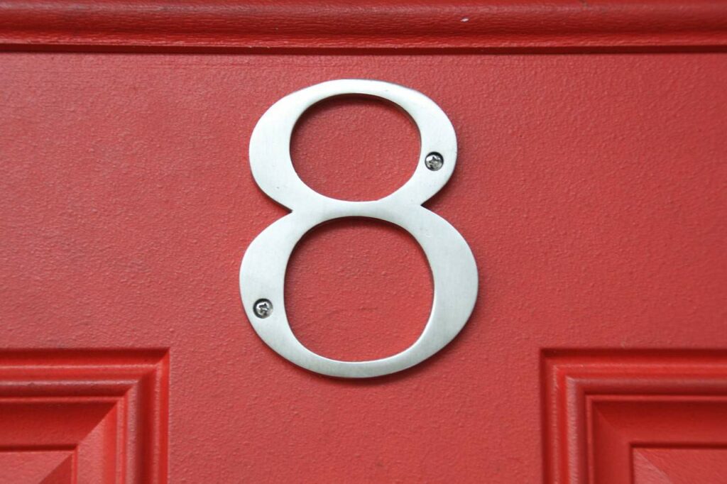 Silver letter eight on a red door 