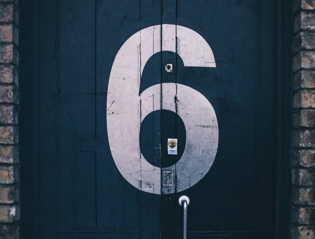 white numeral six stenciled onto a navy blue door
