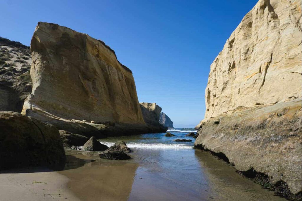 sandstone cliffs on either side with the ocean peeking through the middle at Cape Kiwanda beach, Oregon