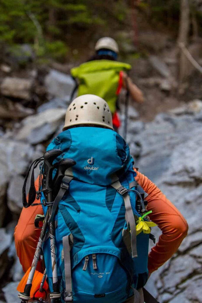 two men in colorful hiking gear making their way up a steep, rocky trail 