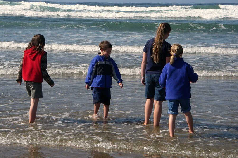 four children playing in the surf on Manzanita Oregon beach