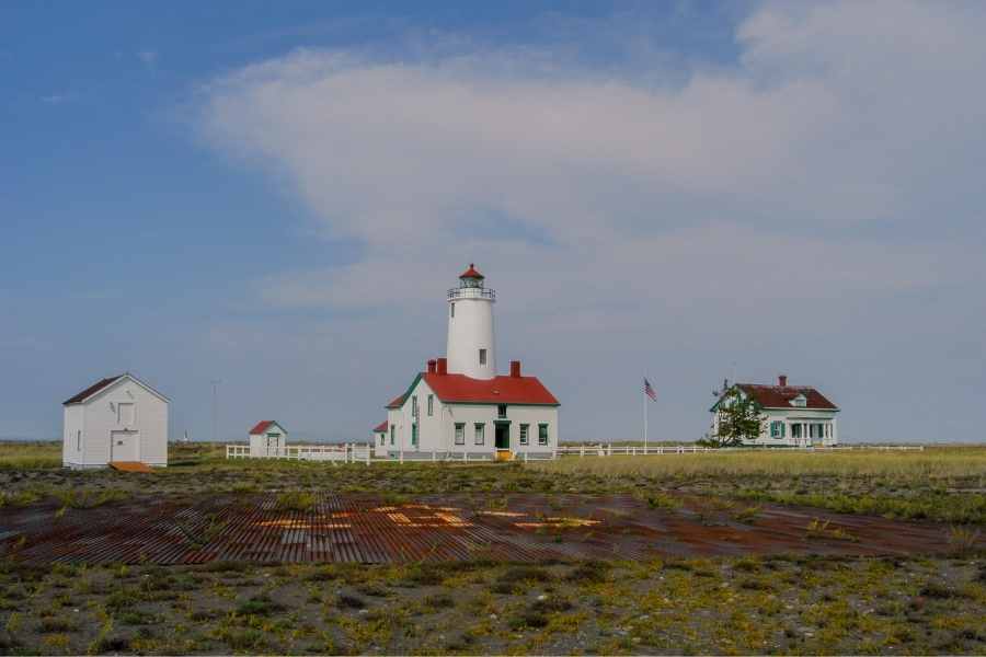 red and white lighthouse and keepers house in the distance in Sequim, Washington