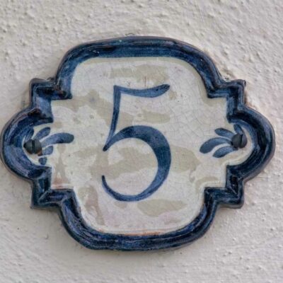 blue numeral five on a dutch-pottery inspired address sign