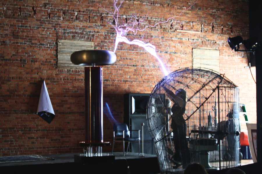 Spark Museum Cage of Doom with a woman inside being "electrocuted" with a bolt of lighting from a giant Tesla Coil