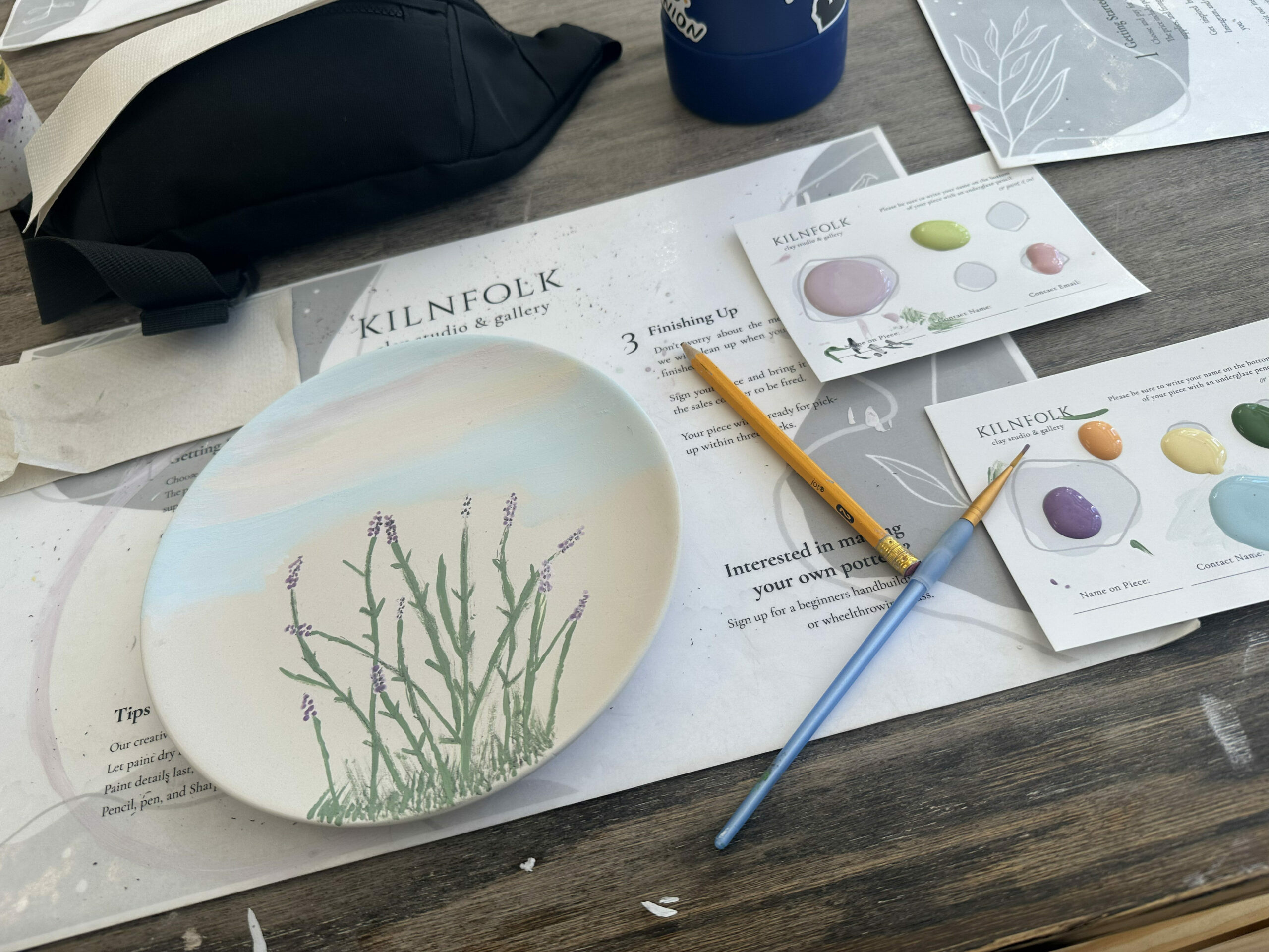paint on paper and with a plate that has lavender painted on it at Kilnfolk pottery in Vancouver, WA