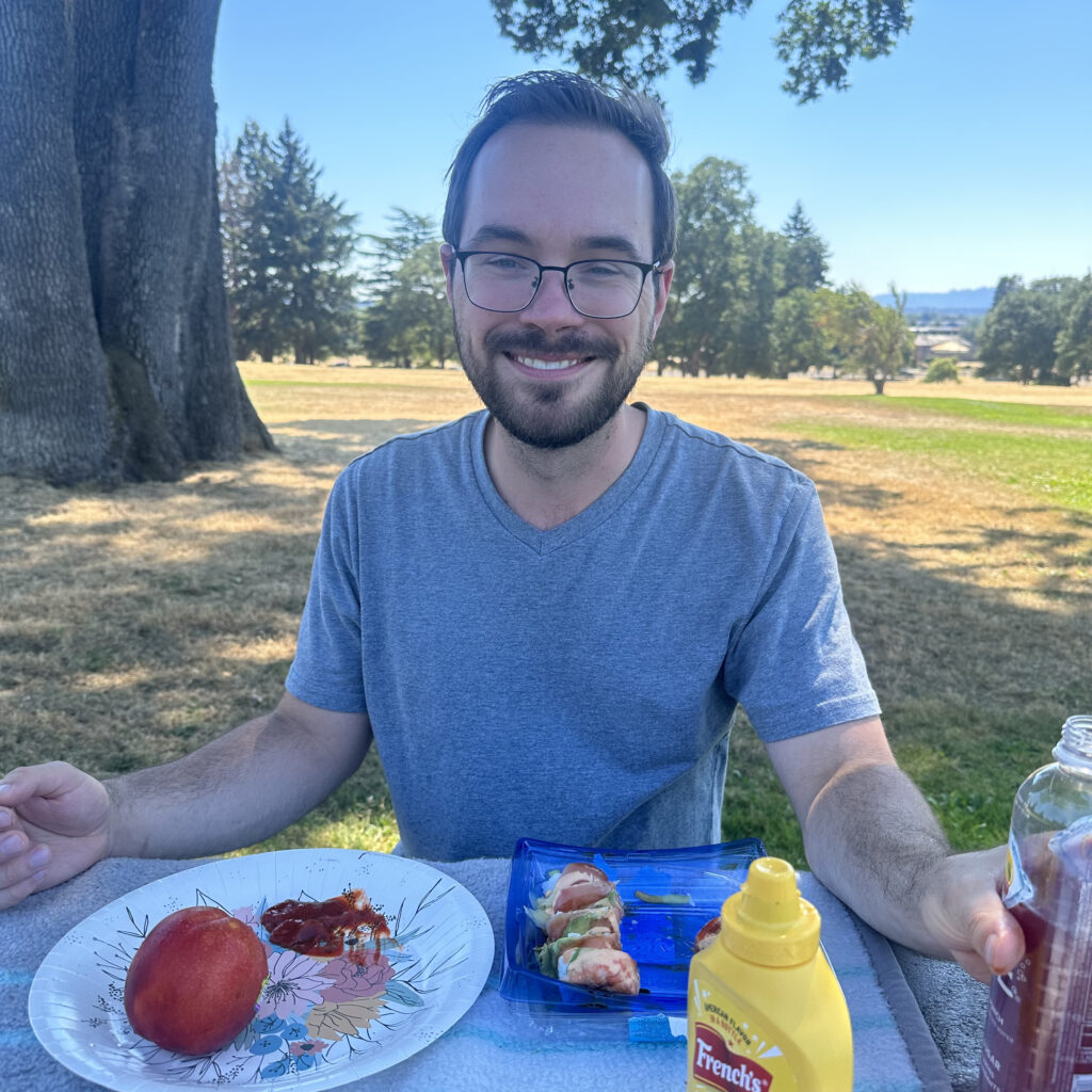 a man smiling and eating a picnic lunch at Fort Vancouver National Historic site  