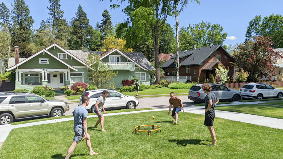 Group of guys playing a game on a grassy lawn.