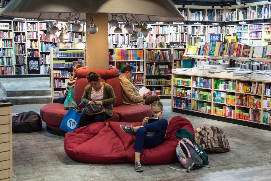 people relaxing on red chairs and bean bags in a bookstore