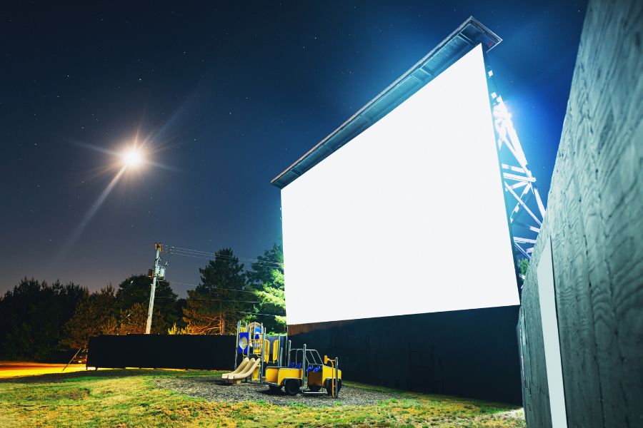 a large movie screen set up in the park