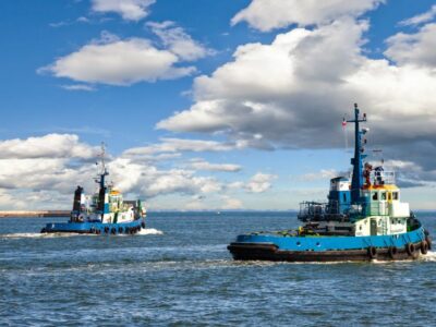 two blue tugboats in the water