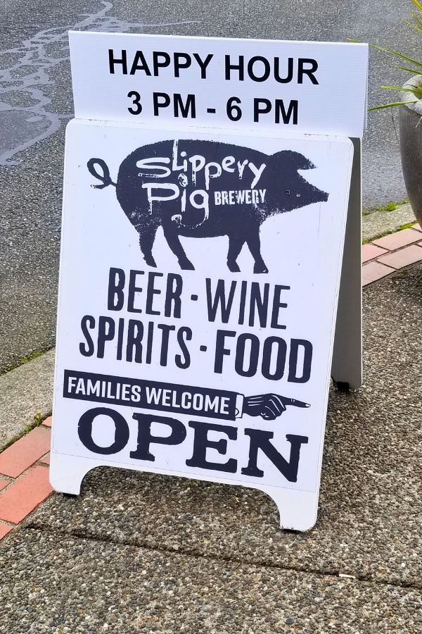 Sandwich board on the sidewalk, pointing passerby to the Slippery Pig in Poulsbo